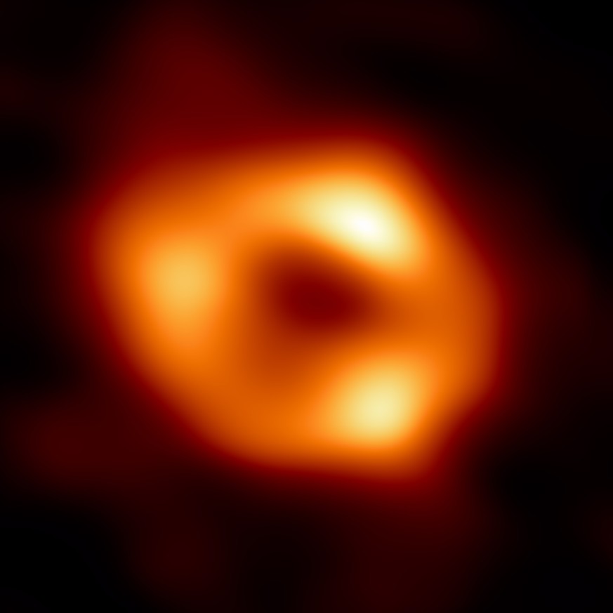 Das Schwarze Loch selber kann nicht beobachtet werden, da kein Licht von dort nach aussen dringen kann. Es ist der dunkle Bereich im Inneren des leuchtenden Rings. Die Aufnahme ist eine Kombination von Daten aus dem Jahr 2017.  
