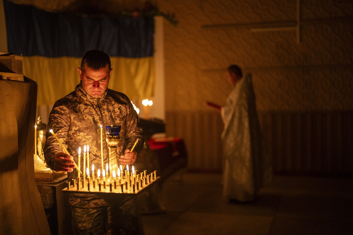 An Ukrainian serviceman of the 72nd Separate Mechanized Brigade, lights candles during a Christian Orthodox Easter religious service, in Donetsk region, Ukraine, Saturday, May 4, 2024. (AP Photo/Franc ...