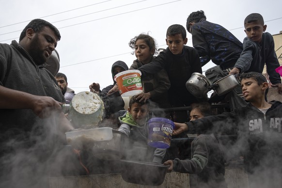 Palestinians line up for a free meal in Rafah, Gaza Strip, Thursday, Dec. 21, 2023. International aid agencies say Gaza is suffering from shortages of food, medicine and other basic supplies as a resu ...