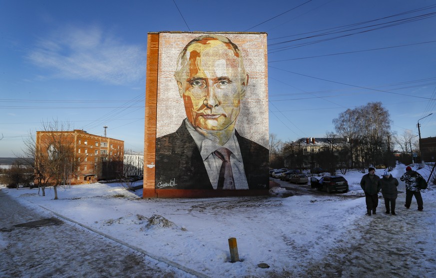 epa10401645 People walk past a large mural depicting Russian President Vladimir Putin, on the side of a five-story residential building in Kashira, Moscow region, Russia, 12 January 2023. The years-ol ...