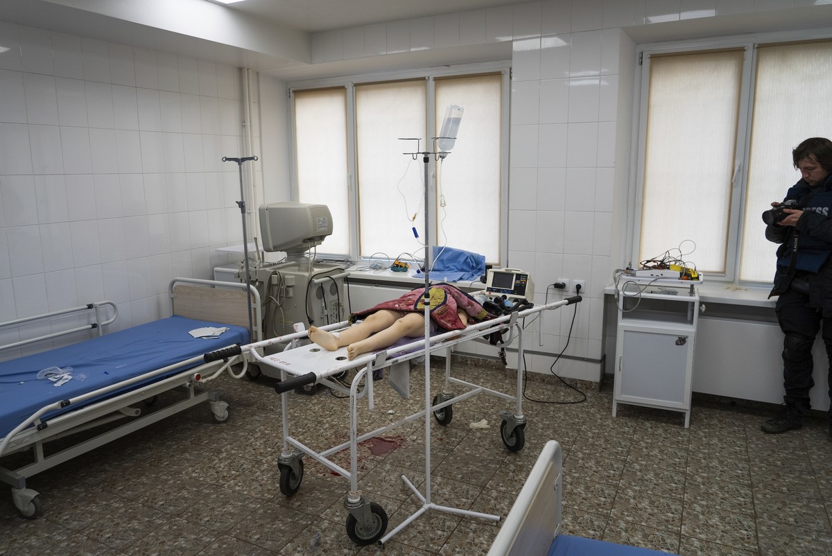 Associated Press photographer Evgeniy Maloletka takes a photo of the lifeless body of a girl, killed from shelling of a residential area, at the city hospital of Mariupol, eastern Ukraine, Sunday, Feb ...