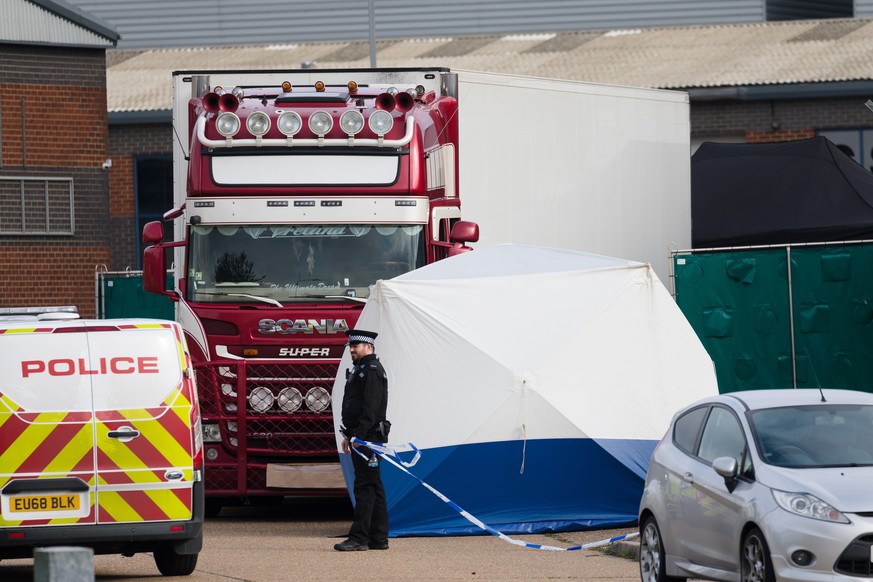 epa07943158 Police officers cordon off the area around the lorry at the scene in Waterglade Industrial Park in Grays, Essex, Britain, 23 October 2019. A total of 39 bodies were discovered inside a lor ...