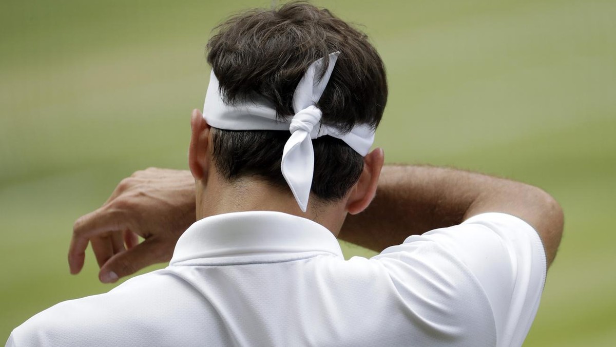 Switzerland's Roger Federer wipes his face during the men's singles final match against Serbia's Novak Djokovic at the Wimbledon Tennis Championships in London, Sunday, July 14, 2019. ( ...