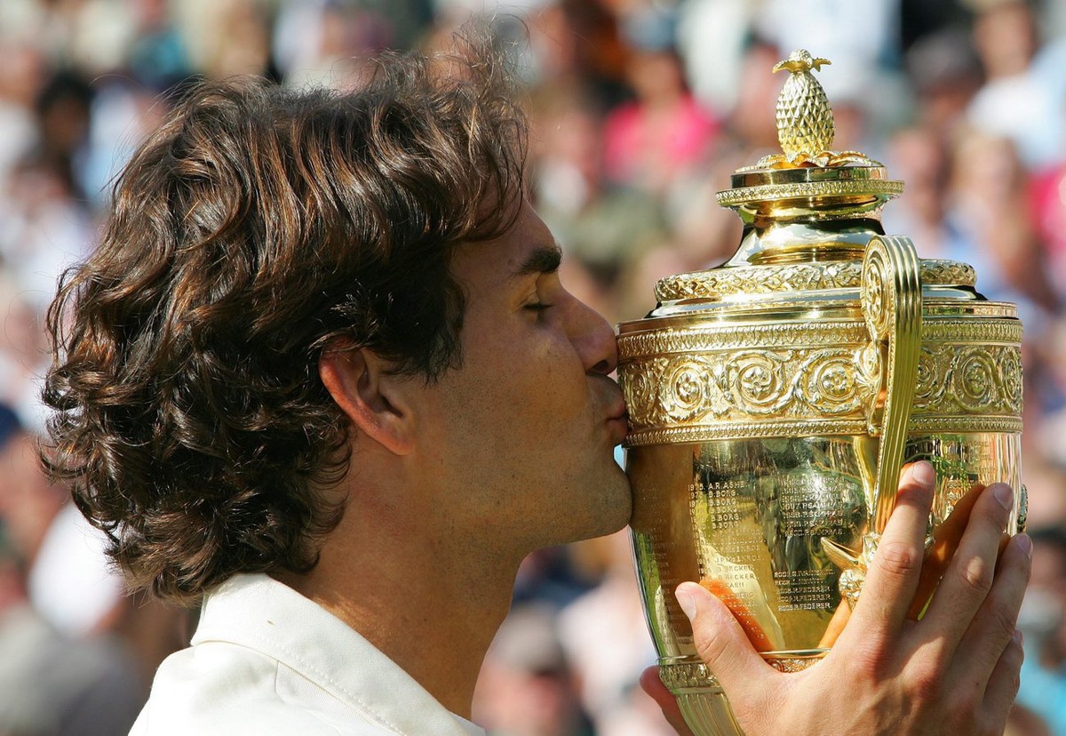 Roger Federer of Switzerland kisses the winner's trophy following his victory over Rafael Nadal of Spain in the men's final of the Wimbledon Championships at the All England Lawn Tennis Club ...
