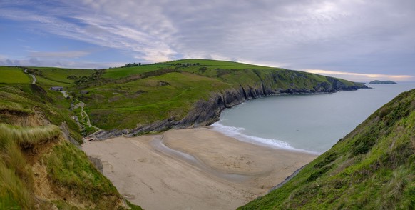 Evening light on the Ceredigion cliffs and Cardigan Island from Mwnt, Wales, Mwnt, Wales - May 23, 2019: Evening light on the Ceredigion coast and Cardigan Island from Traeth Mwnt, Wales, UK