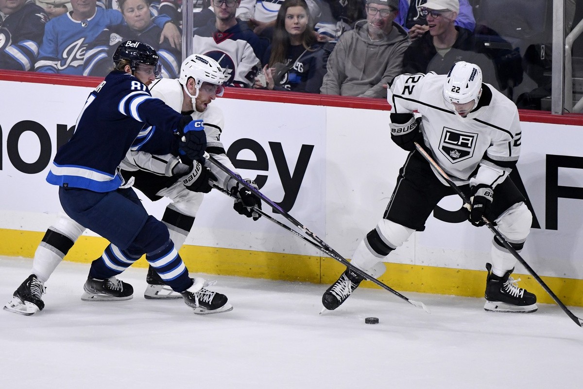 Los Angeles Kings' Pierre-Luc Dubois (80) and Winnipeg Jets' Kyle Connor (81) battle along the boards as Kevin Fiala (22) tries to control the puck during the first period of an NHL hockey g ...
