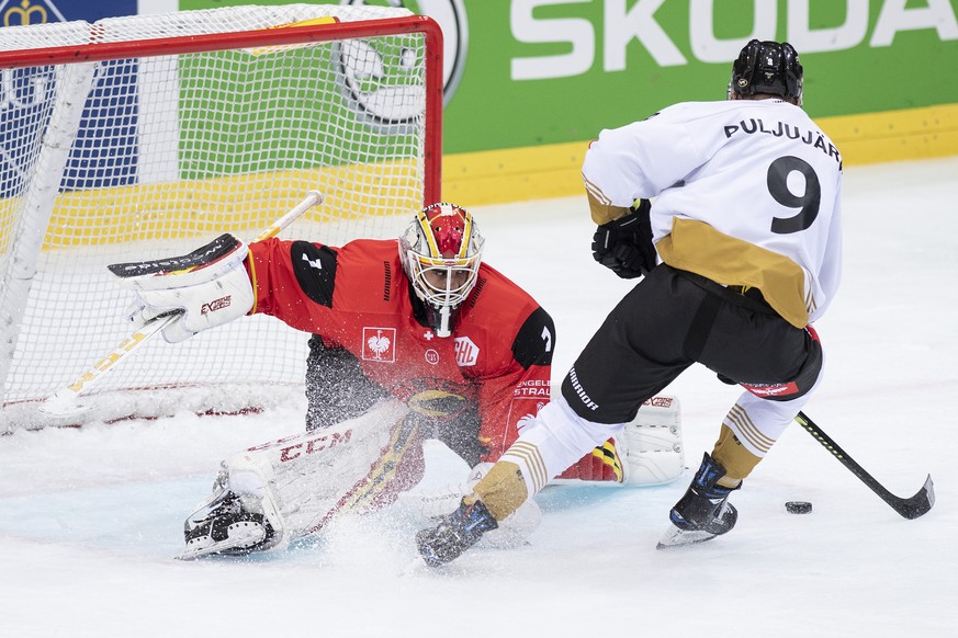 BernÕs goaltender Niklas Schlegel, left, fights for the puck with OuluÕs Jesse Puljujaervi, right, during the Champions Hockey League round of 4 match between Switzerland&#039;s SC Bern and FinlandÕs  ...