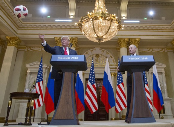 U.S. President Donald Trump, left, tosses a soccer ball to his wife first lady Melania Trump after Russian President Vladimir Putin presented it to him during a press conference after their meeting at ...