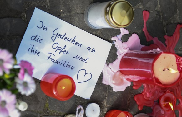 epa06654938 A view of flowers, candles and a postcard at the crime scene in the inner city of Muenster, Germany, 08 April 2018, after a van drove into people sitting outside restaurants in the inner c ...
