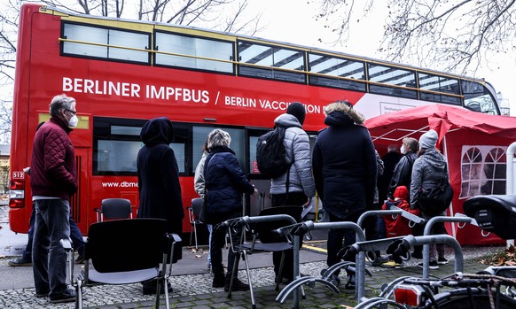 epa09591740 People wait in line to be vaccinated against coronavirus, in front of a vaccination bus in Berlin, Germany, 19 November 2021. Germany is dealing with a high number of new coronavirus COVID ...