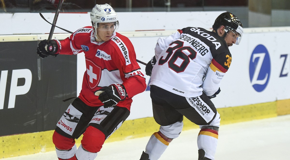 Switzerland's Pius Suter, left, fights for the puck against Germany's Yannic Seidenberg, right, during a friendly international ice hockey game between Switzerland and Germany, at the ice st ...