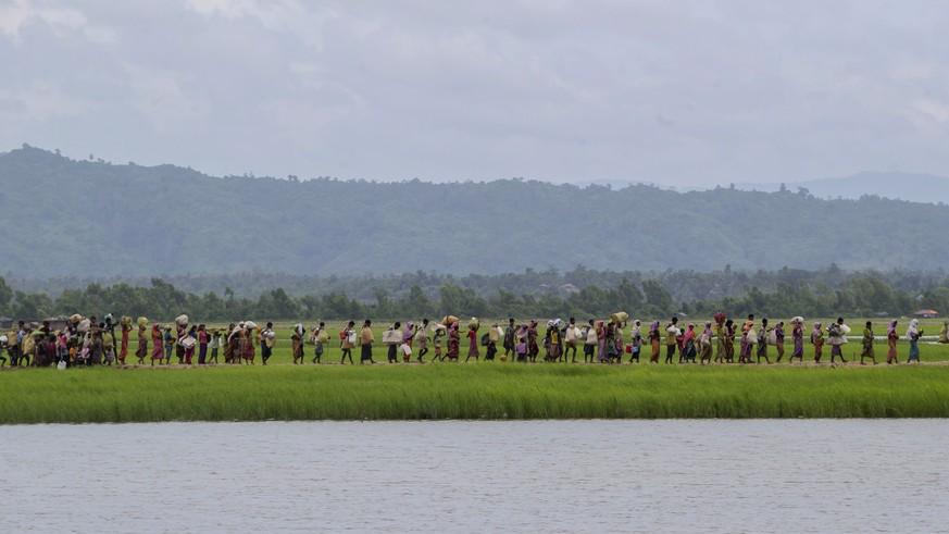 Rohingya Muslims walk towards refugee camps after spending four days in the open, having being earlier prevented by Bangladesh border guards from moving ahead, at Palong Khali, Bangladesh, Thursday, O ...