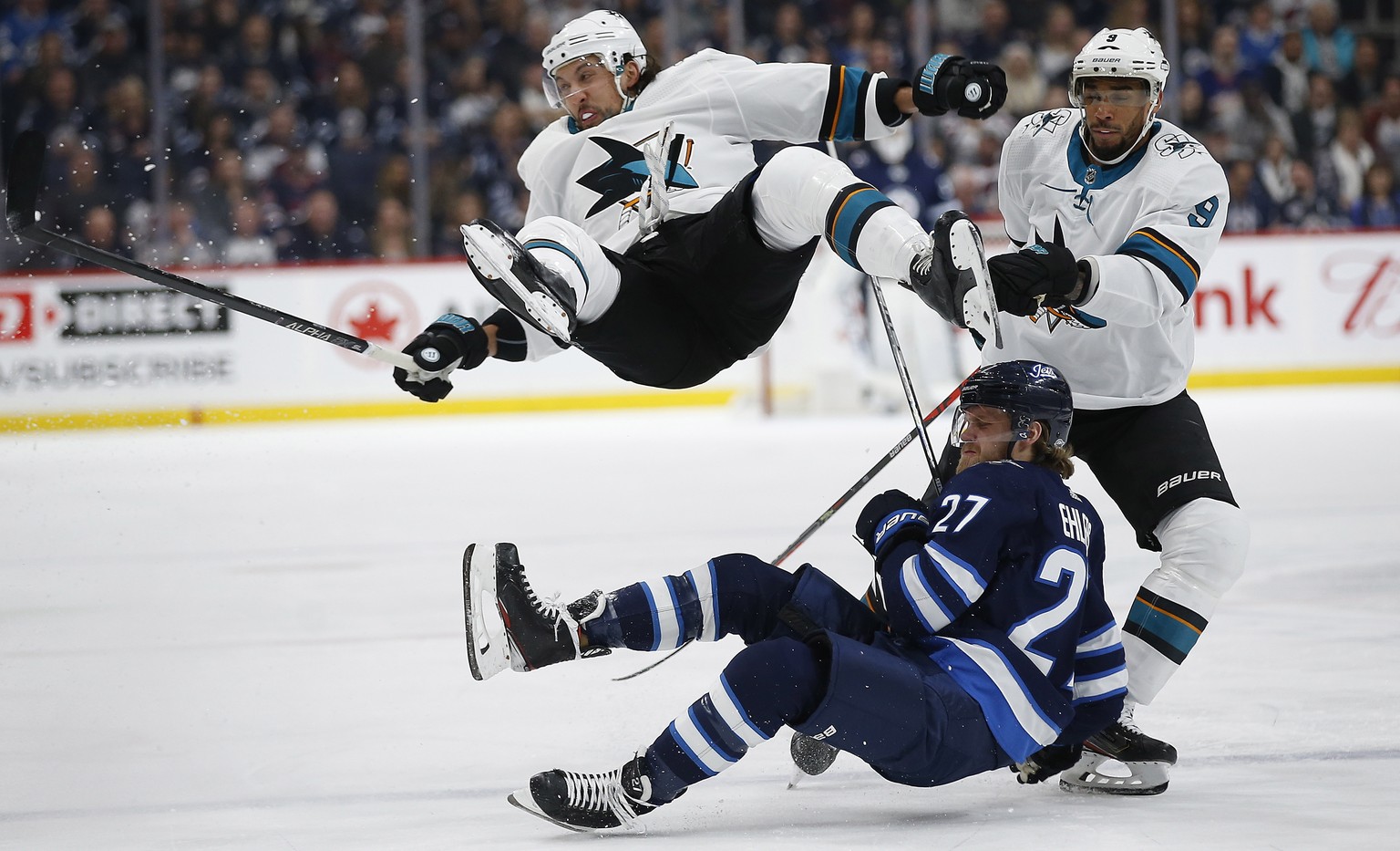 Winnipeg Jets&#039; Nikolaj Ehlers (27) and San Jose Sharks&#039; Brenden Dillon (4) collide as Sharks&#039; Evander Kane (9) skates by during the second period of an NHL hockey game Friday, Feb. 14,  ...