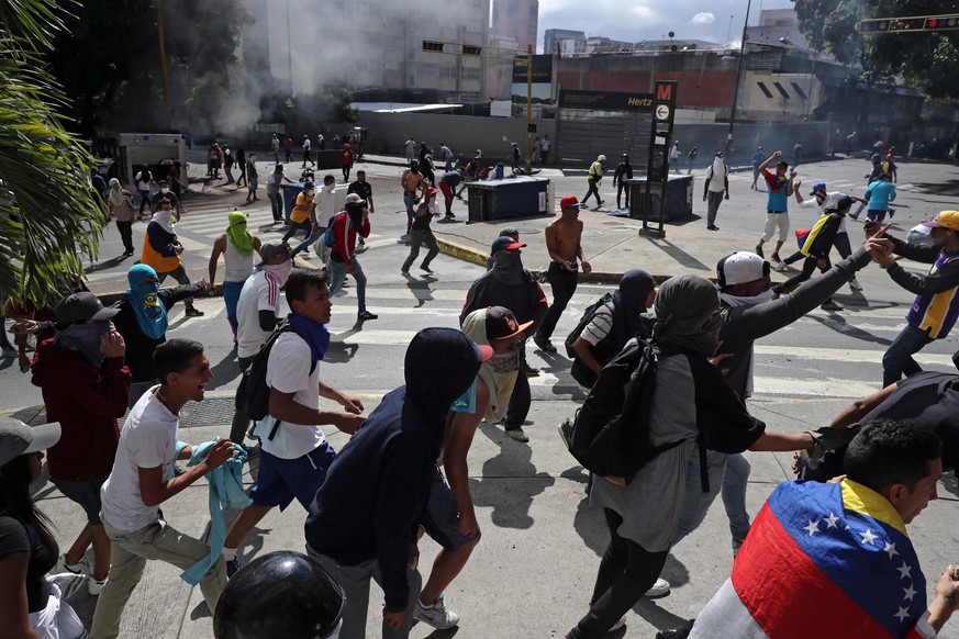 epa07313167 People riot during a protest against President Maduro as Juan Guaido, President of the Venezuelan Parliament, announces that he assumes executive powers, in Caracas, Venezuela, 23 January  ...