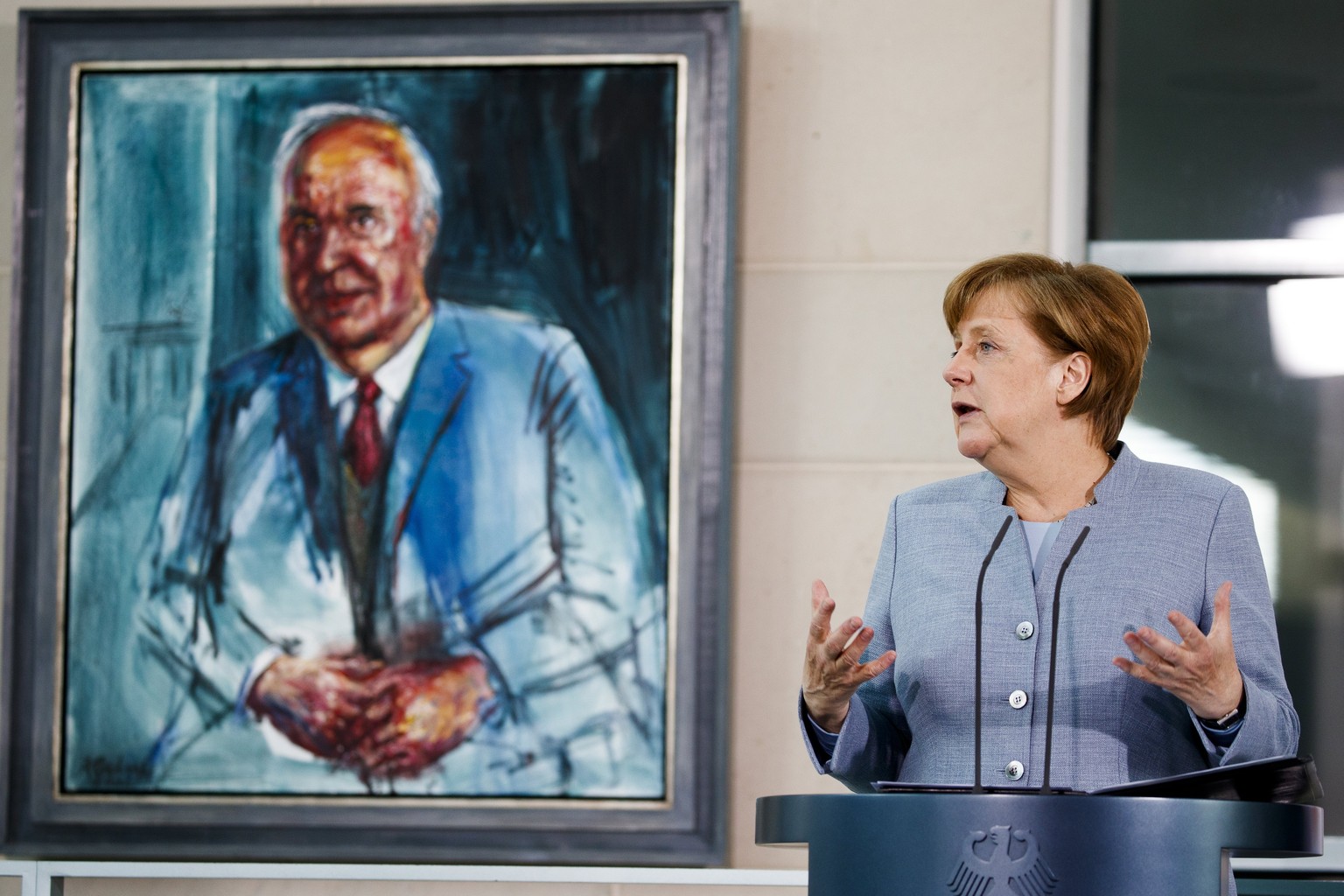 epa06031816 (FILE) - German Chancellor Angela Merkel speaks to participants beside a painting of former Chancellor Helmut Kohl, during the kick-off event for the 17th Girls Day at the Chancellory in B ...