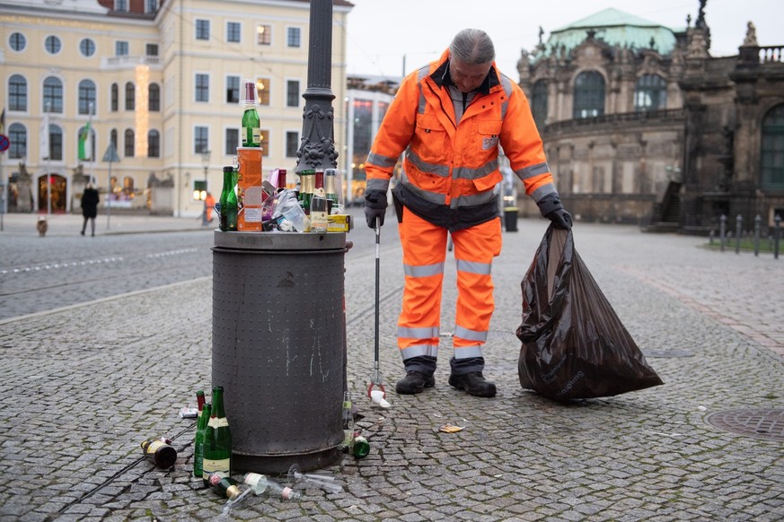 01.01.2020, Sachsen, Dresden: Michael Gärtner, Mitarbeiter Stadtreinigung Dresden, sammelt Müll nach der Silvesternacht am Theaterplatz. Foto: Sebastian Kahnert/dpa-Zentralbild/dpa +++ dpa-Bildfunk ++ ...