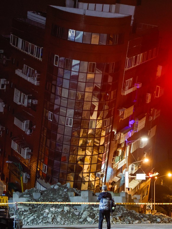 epa11257867 A man takes photos of a partially collapsed residential building following the 03 April magnitude 7.4 earthquake in Hualien, Taiwan, 04 April 2024. According to data released by Taiwan&#03 ...