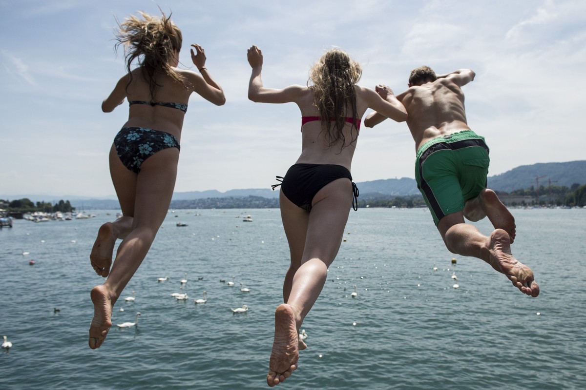 Junge Menschen kuehlen sich mit einem Sprung in den Zuerichsee ab, aufgenommen am Samstag, 19. Juli 2014 in Zuerich. (KEYSTONE/Ennio Leanza)....Young people jump into the Lake Zurich in Zurich, Switze ...