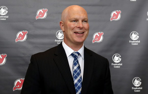 John Hynes smiles after being announced as the new head coach of the New Jersey Devils during an NHL hockey news conference, Tuesday, June 2, 2015, in Newark, N.J. (AP Photo/Julio Cortez)