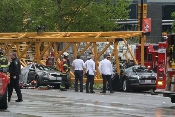 Emergency crews work at the scene of a construction crane collapse near the intersection of Mercer Street and Fairview Avenue near Interstate 5 Saturday, April 27, 2019, in Seattle. Several people wer ...