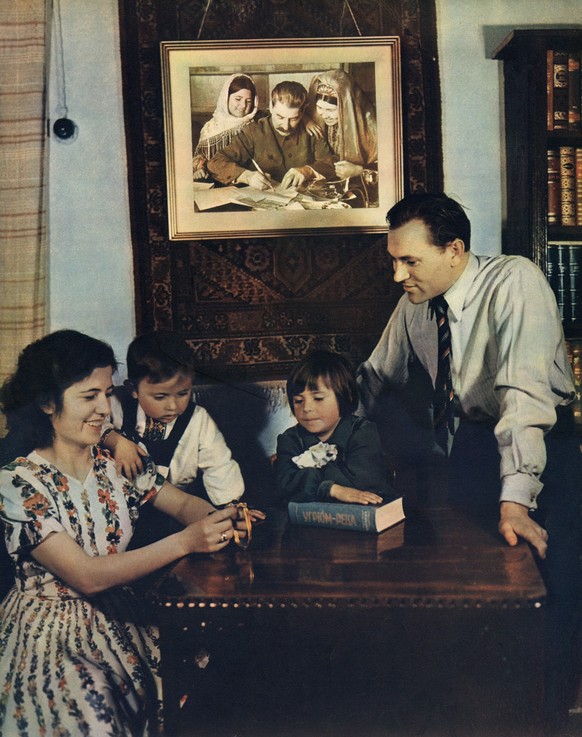 Stalin (Josif Visarionovic 1879-1953) Personality Cult: photograph published on &#039;Union Soviétique - Mai 1953&#039; (two months after the Stalin&#039;s death). A typical Soviet family portrayed in ...