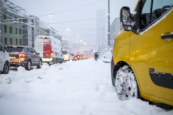 Ein Postfahrzeug mit Schneeketten an der verschneiten verschneiten Hoenggerstrasse, fotografiert am 15. Januar 2021 in Zuerich. (KEYSTONE/Christian Beutler)