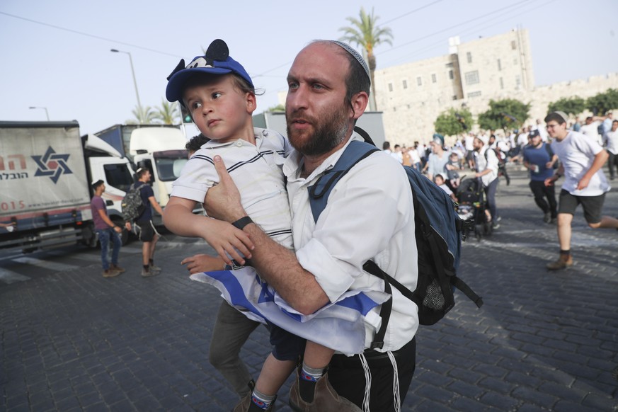 Begleitet von Sirenen: Ein Israelite rennt mit seinem Sohn während eines Luftangriffes durch Jerusalems Strassen.