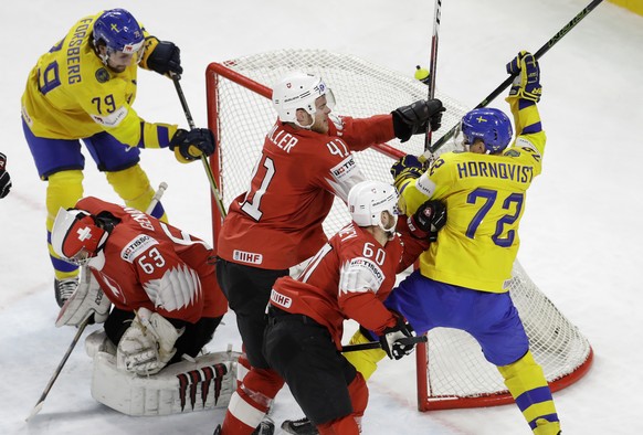 Switzerland&#039;s Mirco Muller, centre and Tristan Scherwey block Sweden&#039;s Patric Hornqvist, right, during the Ice Hockey World Championships final match between Sweden and Switzerland at the Ro ...