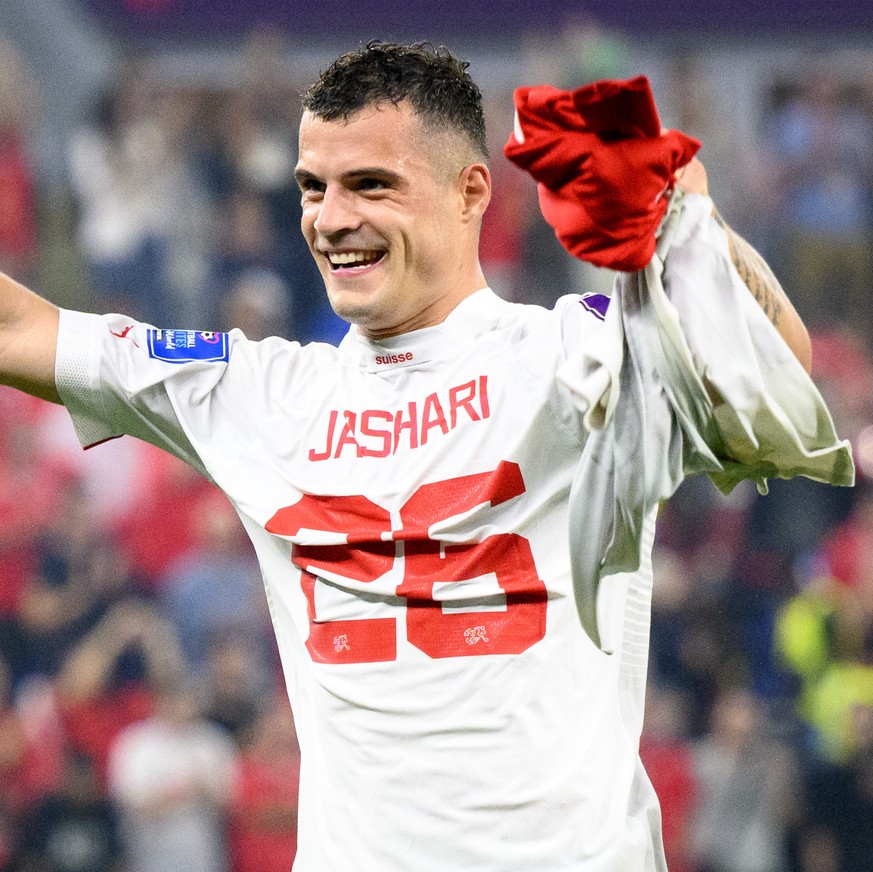 Switzerland's midfielder Granit Xhaka celebrates the victory and the qualification with the shirt of Switzerland's midfielder Ardon Jashari after the FIFA World Cup Qatar 2022 group G soccer ...