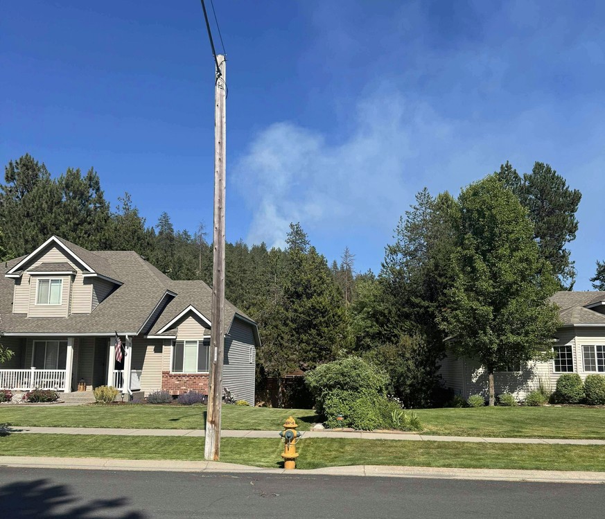 In this photo provided by Mark Lathrop, a blaze burns in a community near Canfield Mountain where a sniper ambushed firefighters responding to the fire, just north of Coeur d&#039;Alene, Idaho, Sunday ...