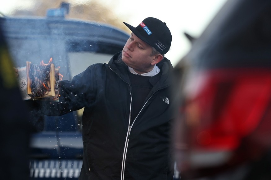 epa10433884 Rasmus Paludan, leader of Danish far-right anti-Islam party Stram Kurs (Hard Line), burns a copy of the Koran in front of the Turkish embassy in Copenhagen, Denmark, 27 January 2023. The a ...