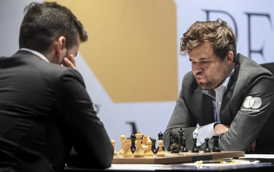 epa09633987 Defending Champion Magnus Carlsen (R) of Norway plays against Ian Nepomniachtchi of Russia during the 11th round of FIDE World Chess Championship at the EXPO 2020 Dubai in Dubai, United Ar ...