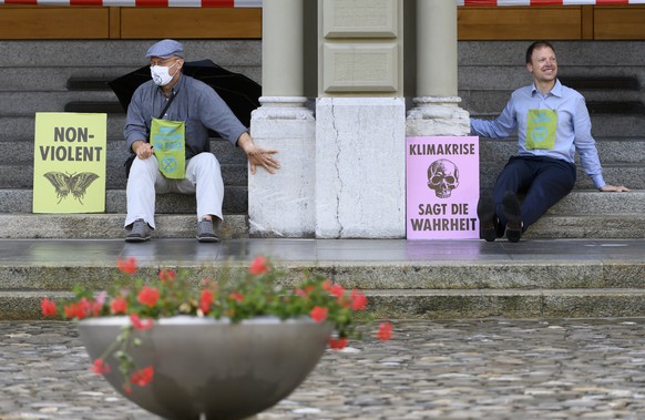 Zwei Extinction Rebellion-Aktivisten demonstrieren und haben ihre Haende an die Mauern des Bundeshauses geklebt, am Dienstag, 22. Juni 2021, in Bern. Die Aktion von Exinction Rebellion fand anlaesslic ...