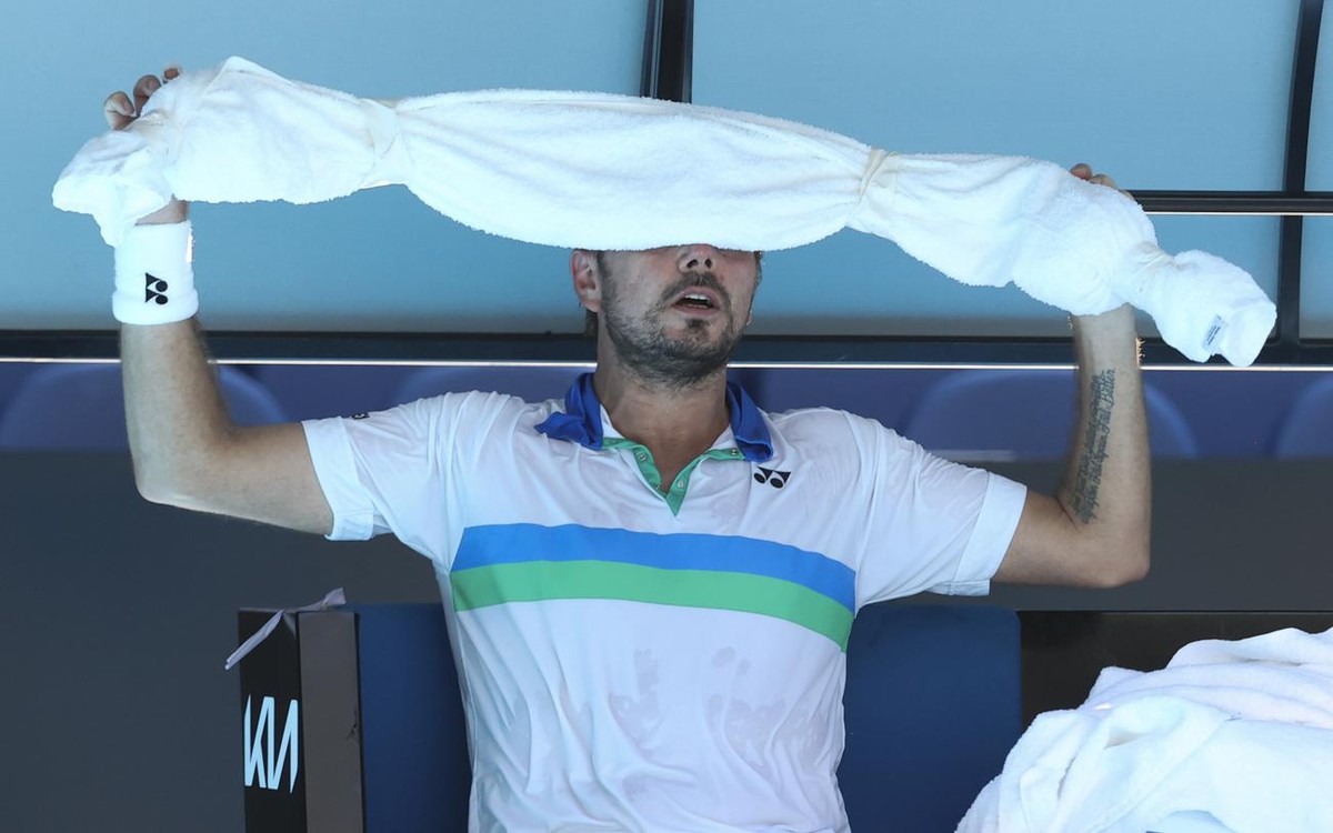 Switzerland's Stan Wawrinka holds an ice towel to his head during his second round match against Hungary's Marton Fucsovics at the Australian Open tennis championship in Melbourne, Australia ...