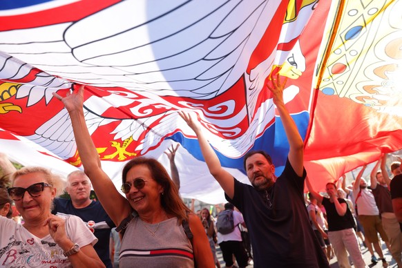 epa12203348 Protesters wave a giant Serbian flag during a student-led rally in Belgrade, Serbia, 28 June 2025. University students are demanding accountability and calling on early elections after six ...