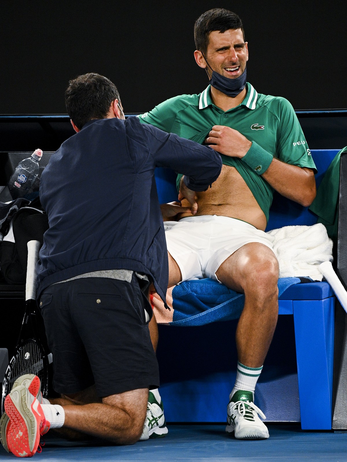 epa09006643 Novak Djokovic of Serbia receives medical attention during his third Round Men's singles match against Taylor Fritz of the United States of America on Day 5 of the Australian Open at  ...