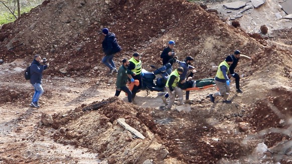 epa11855151 People carry an injured person on a road leading to their village after a confrontation with Israeli soldiers positioned in Meiss al-Jabal, Marjayoun District, southern Lebanon, 26 January ...