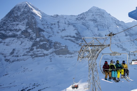 Skifahrer mit Schutzmaske auf dem Sessellift Lauberhorn vor dem Eiger Moench, aufgenommen am Freitag, 8. Januar 2021, im Skigebiet Grindelwald - Wengen. Die Berner Skigebiete bleiben trotz Coronavirus ...
