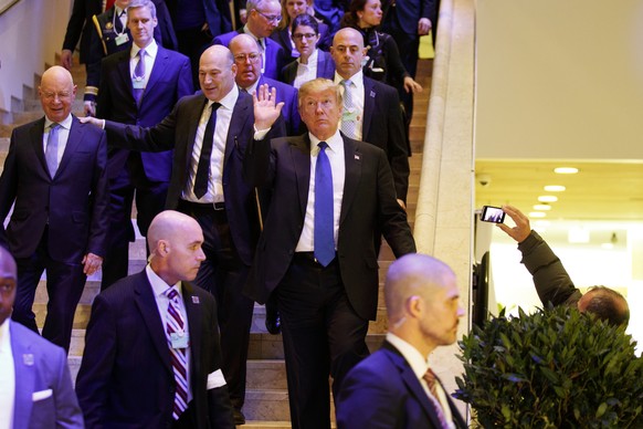 President Donald Trump waves as he walks to a dinner with European business leaders at the World Economic Forum, Thursday, Jan. 25, 2018, in Davos. (AP Photo/Evan Vucci)