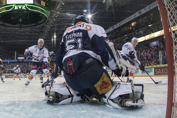 Torhueter Tobias Stephan, mitte, von Zug klaert einen ZSC Angriff im fuenften Eishockey Playoff-Viertelfinalspiel der National League zwischen dem EV Zug und den ZSC Lions, am Dienstag, 20. Maerz 2018 ...