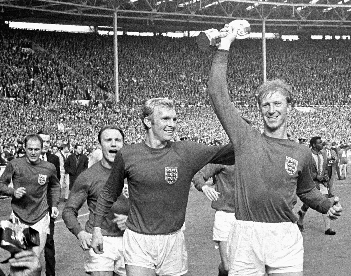 FILE - In this July 30, 1966 file photo England's Jack Charlton, right, holds the Jules Rimet trophy aloft as he parades it around Wembley with teammate Bobby Moore following their 4-2 win over W ...