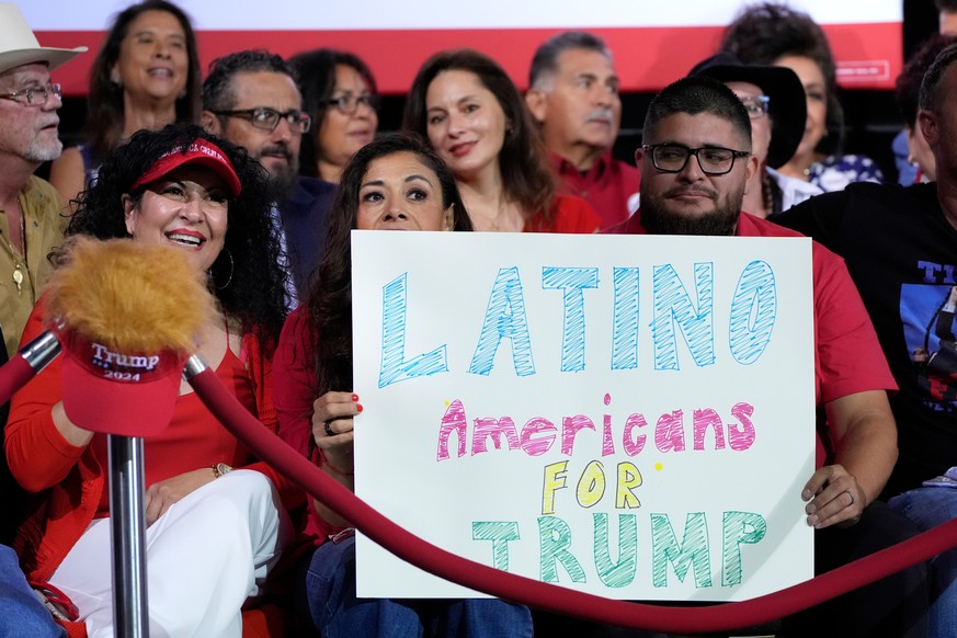 FILE - Supporters hold a sign before Republican presidential nominee former President Donald Trump arrives to speak during a campaign event, Sept.12, 2024, in Tucson, Ariz. (AP Photo/Alex Brandon, Fil ...