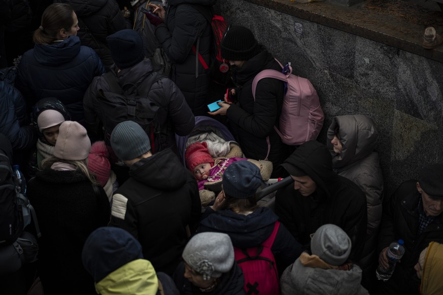 Passengers wait for a train to Poland, inside Lviv railway station, Sunday, Feb. 27, 2022, in Lviv, west Ukraine. (AP Photo/Bernat Armangue)