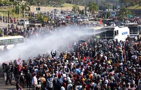 epa08995536 Police fire a water cannon at demonstrators during a protest against the military coup in Naypyitaw, Myanmar, 08 February 2021. Thousands of people took to the streets of Yangon and other  ...