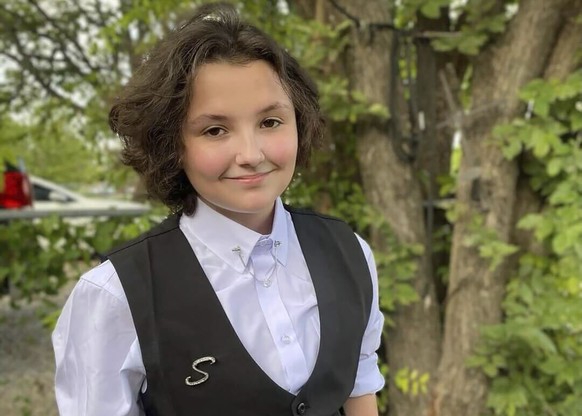 FILE - In this image provided Malia Pila, Nex Benedict poses outside the family&#039;s home in Owasso, Okla., in December 2023. The death of Nex Benedict, a nonbinary student the day after a fight ins ...