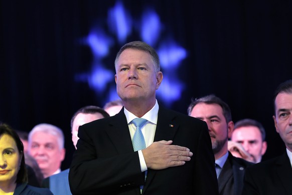 epa07954723 Romania&#039;s acting president Klaus Iohannis, backed by PNL members, stands still during the national anthem at the beginning of a National Liberal Party (PNL) rally held in Bucharest, R ...