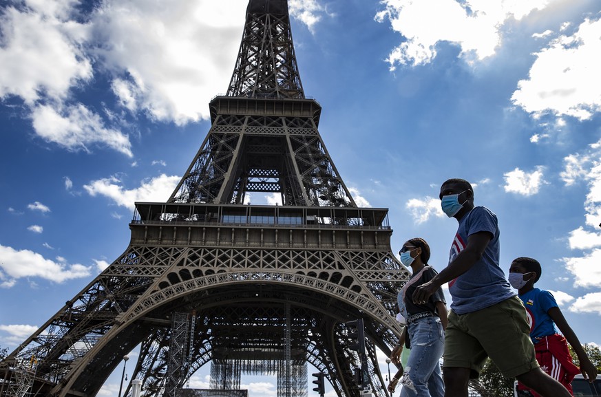 Touristen vor dem Eiffelturm in Paris: Auf den Strassen gilt eine Maskenpflicht.