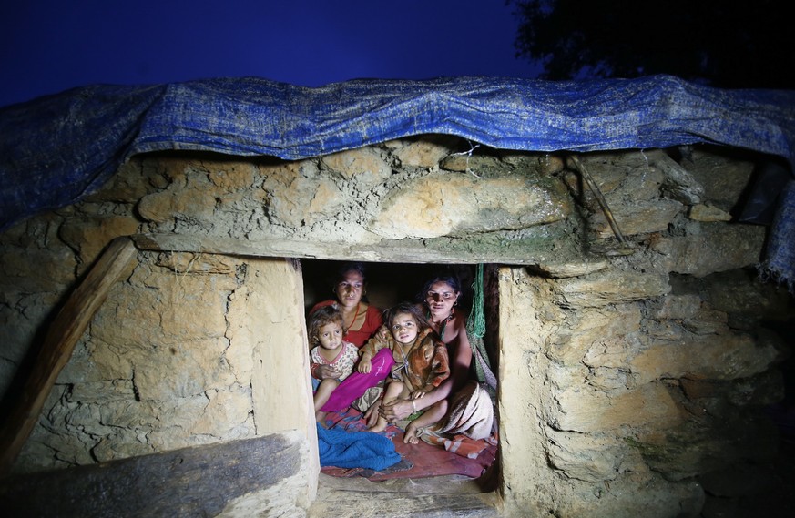 epa07308059 (FILE) - Pabitra Devi Jaisi (R), aged 29, and Sarada Jaisi (L), aged 30, share a tiny community &#039;Chapuadi&#039; hut with their children at Mastamandali village in Acham disctrict, Nep ...