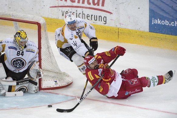 Tigers Roland Gerber, rechts, kaempft um den Puck, gegen Luganos Goalie Daniel Manzato, links, und Alessandro Chiesa, Mitte, waehrend dem Meisterschaftsspiel der National League, zwischen den SCL Tige ...