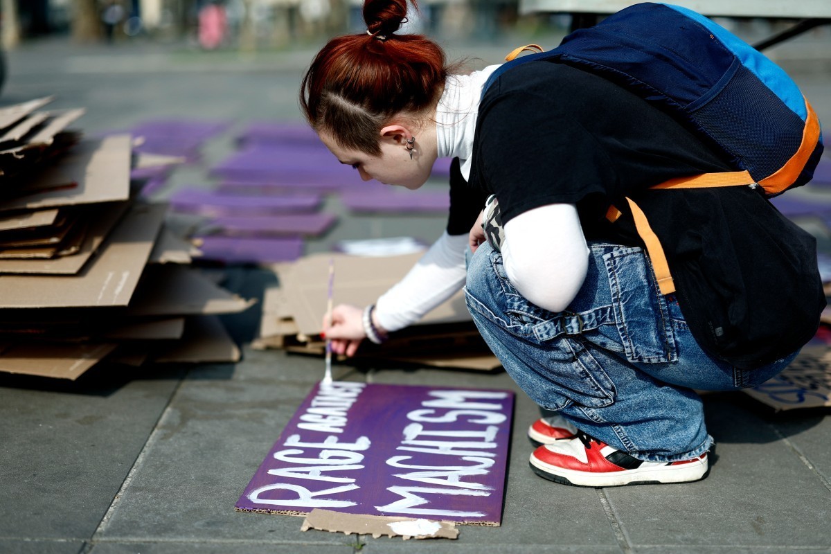A person prepares a sign reading "Rage against Machism" during a gathering organised by the French collective NousToutes (Us all) as part of the International Women's Day in Paris on Ma ...